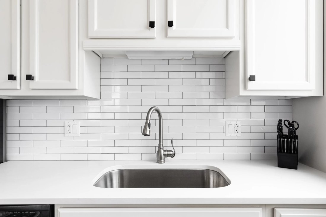 Cucina con rivestimento in piastrelle bianche posate a corsi sfalsati